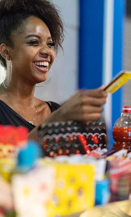 Brazil – Young woman paying for products with a prepaid credit card.