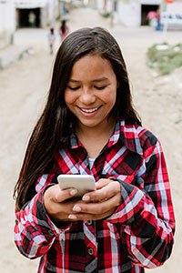 Colombia – Preteen girl looking at online content on her cell phone.